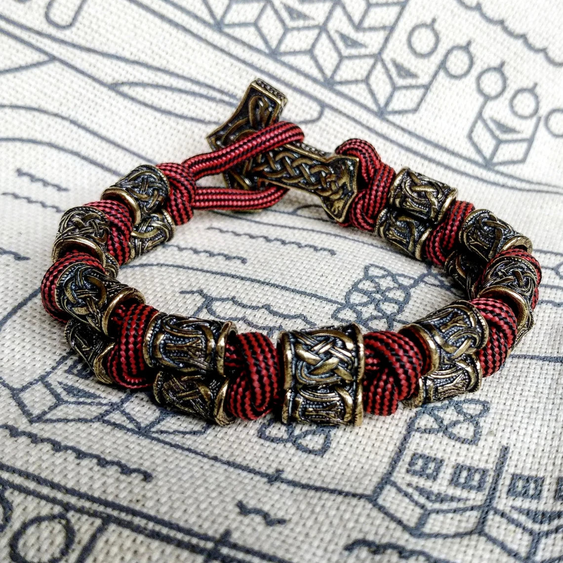 Runic bracelet "VIKING" from a paracord with a clasp "THOR'S HAMMER". Runes "teyvaz" and "algiz". Viking style.