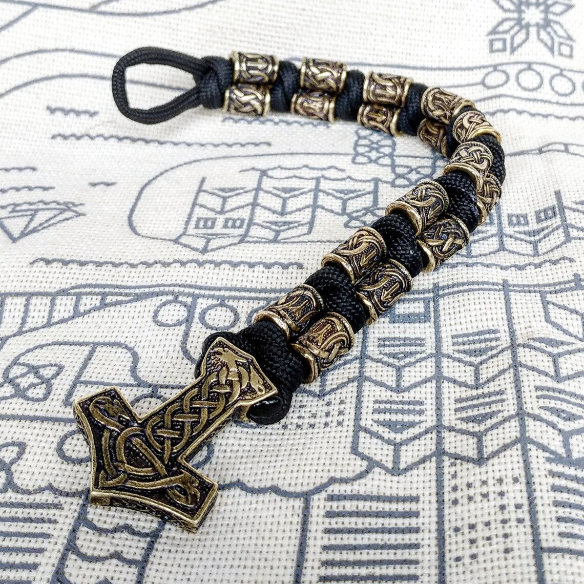 Runic bracelet "VIKING" from a paracord with a clasp "THOR'S HAMMER". Runes "teyvaz" and "algiz". Viking style.