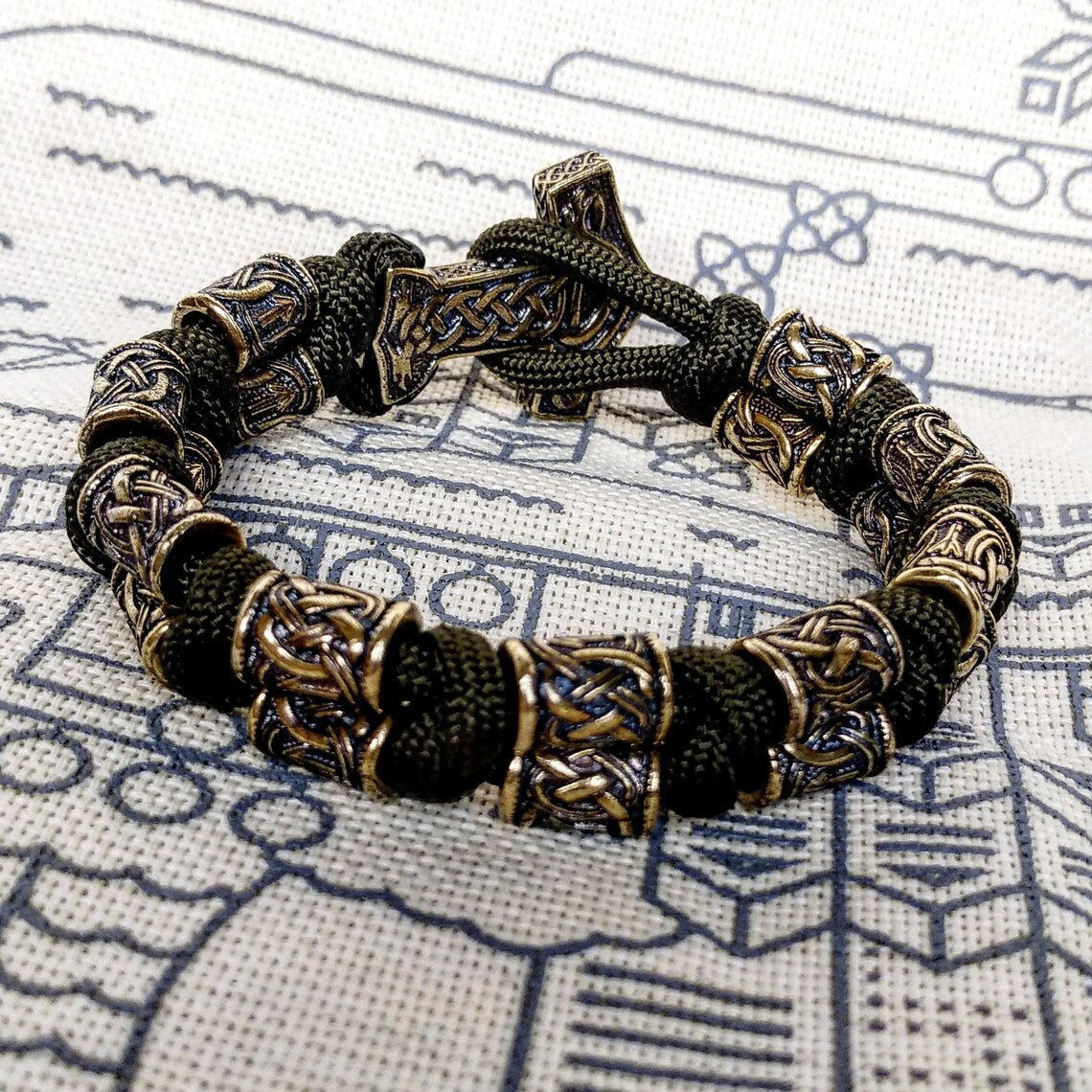 Runic bracelet "VIKING" from a paracord with a clasp "THOR'S HAMMER". Runes "teyvaz" and "algiz". Viking style.