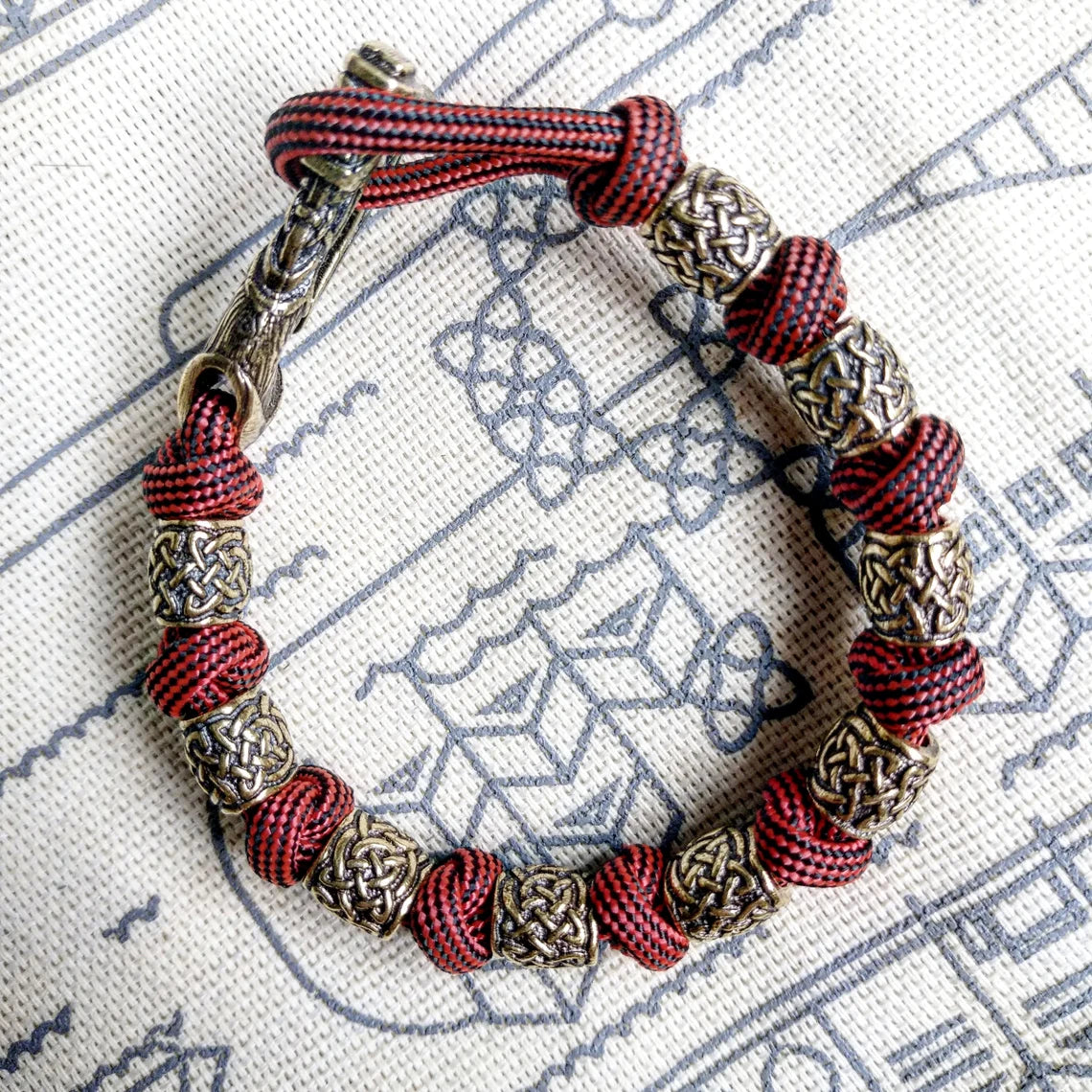 Viking bracelet made of paracord, Celtic knots and original beads made of brass with the image of ancient Scandinavian patterns. Mens style.