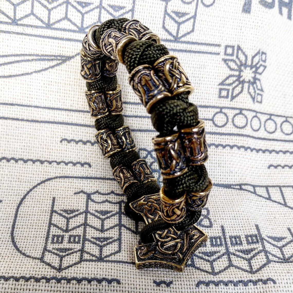 Runic bracelet "VIKING" from a paracord with a clasp "THOR'S HAMMER". Runes "teyvaz" and "algiz". Viking style.