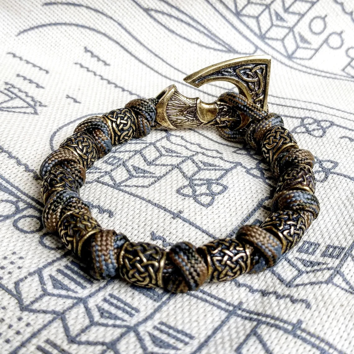 Viking bracelet made of paracord, Celtic knots and original beads made of brass with the image of ancient Scandinavian patterns. Mens style.