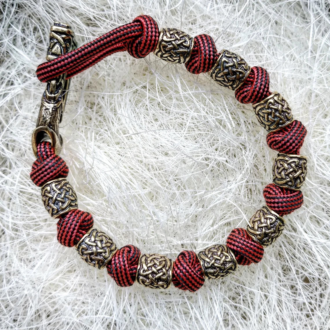 Viking bracelet made of paracord, Celtic knots and original beads made of brass with the image of ancient Scandinavian patterns. Mens style.