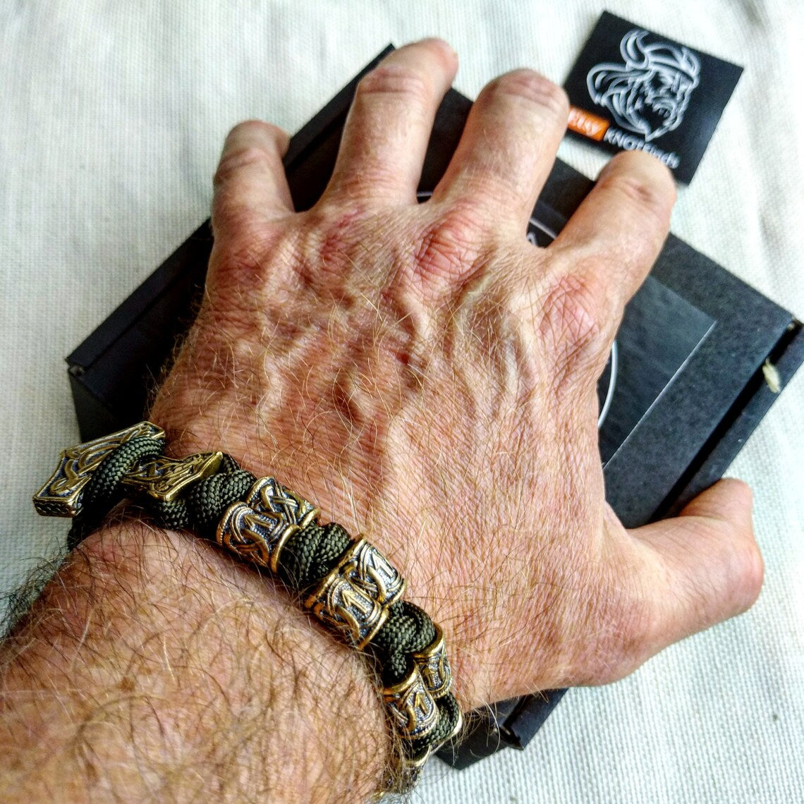 Runic bracelet "VIKING" from a paracord with a clasp "THOR'S HAMMER". Runes "teyvaz" and "algiz". Viking style.