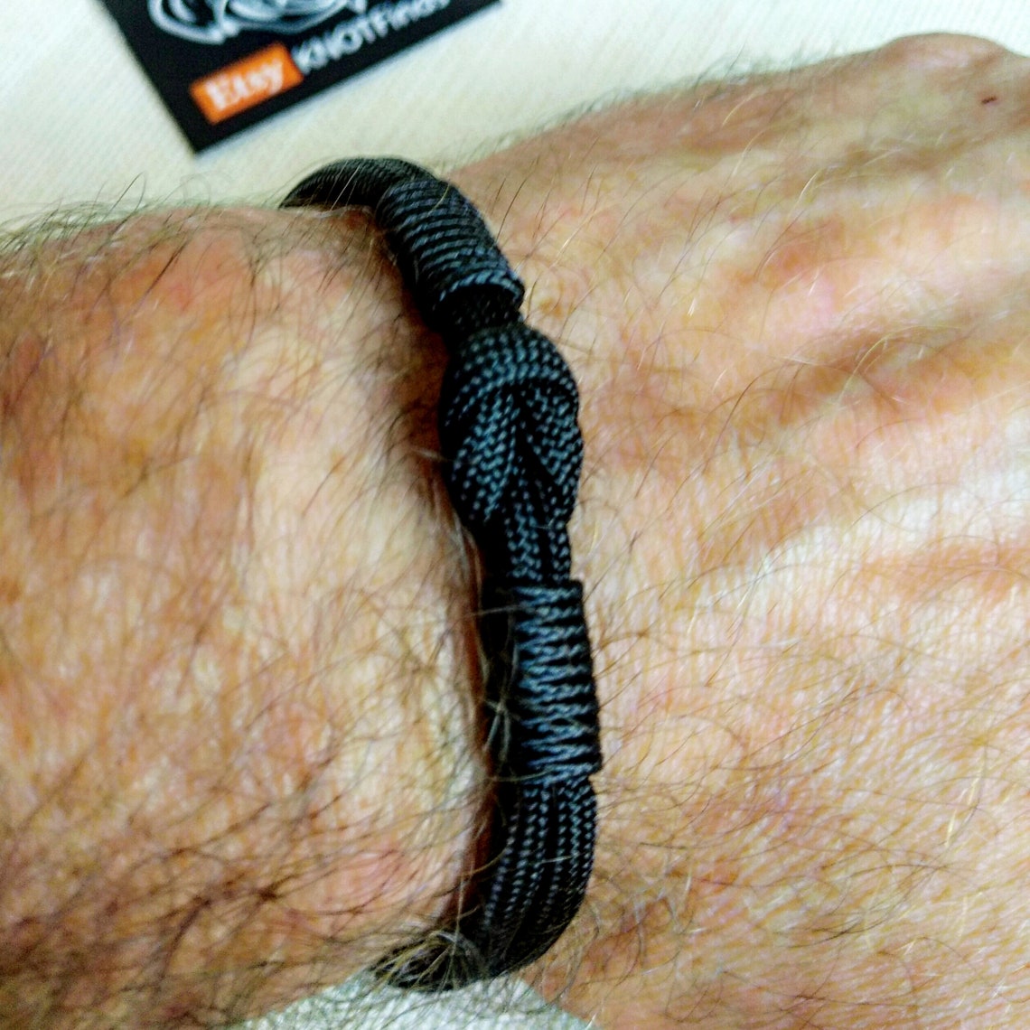 Thin military black bracelet made of paracord and carabine for men. Army style.