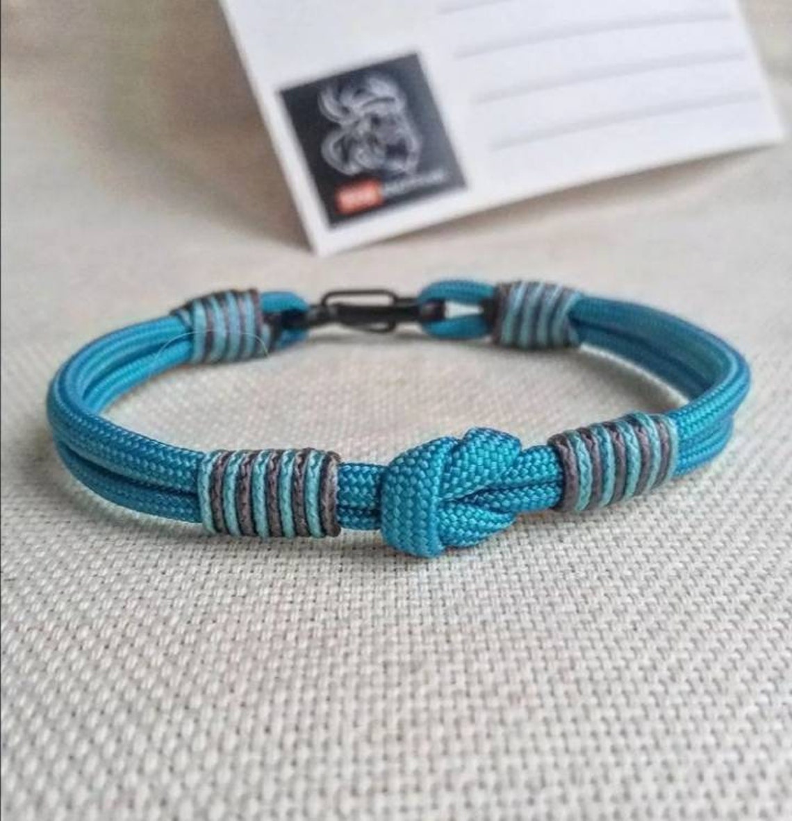 Turquoise thin Nordic paracord bangle with a carabiner. Made of parachute cord and celtic knots. Gift to a friend for his birthday.