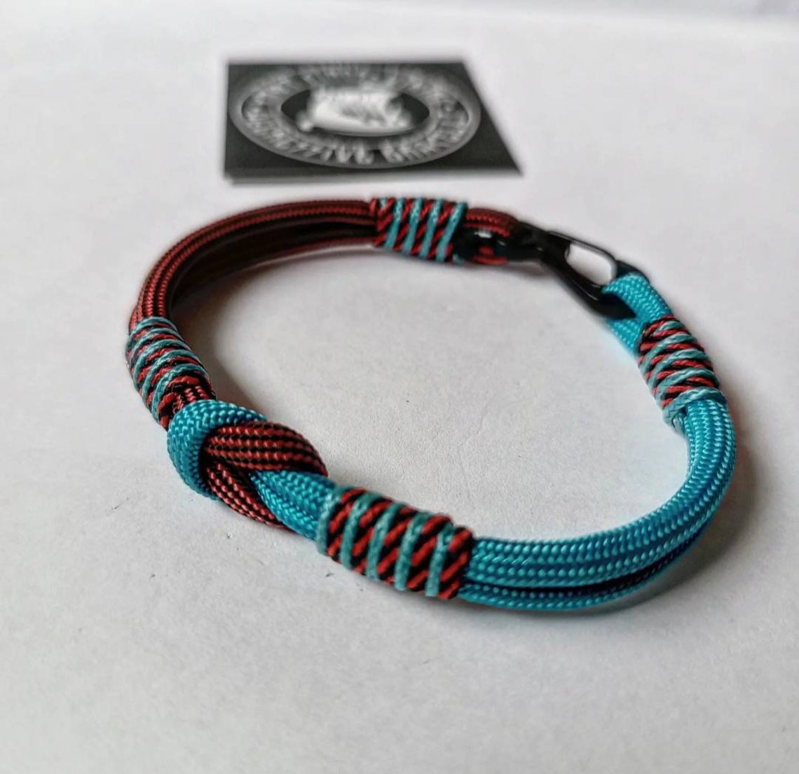 Turquoise and bloody stripe thin Nordic paracord bangle with a carabiner. Made of parachute cord and celtic knots.