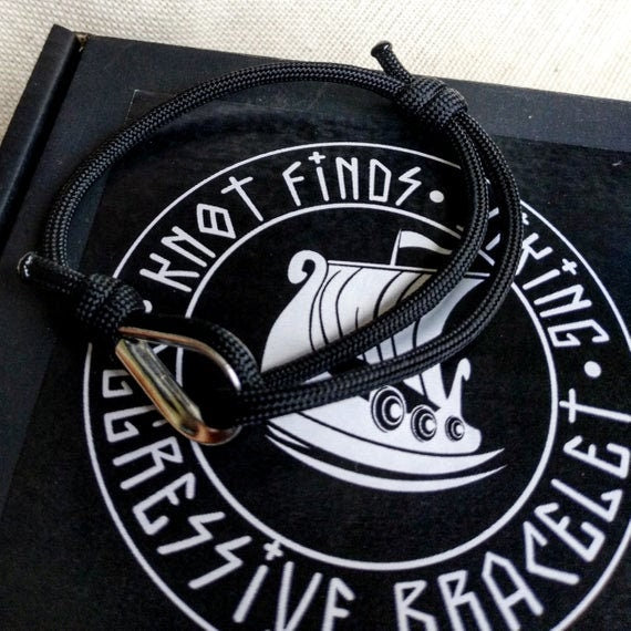 Black thin bracelet made of paracord and Celtic knots. Stylish bracelet for men and women. A gift for a surfer, diver, skydiver.