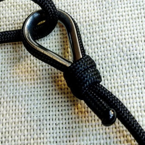 Black thin bracelet made of paracord and Celtic knots. Stylish bracelet for men and women. A gift for a surfer, diver, skydiver.