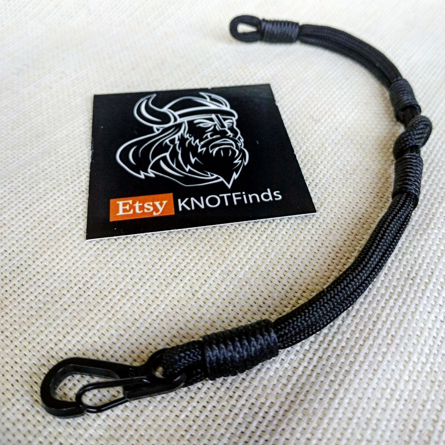 Thin military black bracelet made of paracord and carabine for men. Army style.