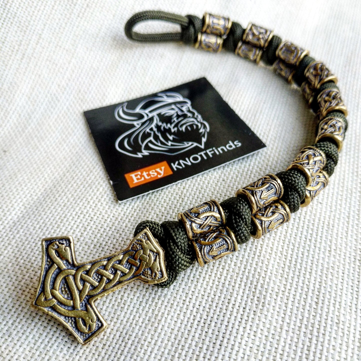 Runic bracelet "VIKING" from a paracord with a clasp "THOR'S HAMMER". Runes "teyvaz" and "algiz". Viking style.