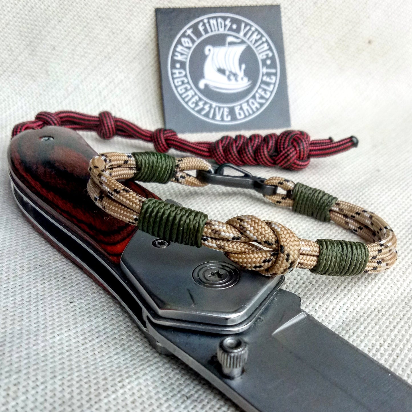 Thin military bracelet made of paracord and carabine for men. Camouflage desert camo. Army style.