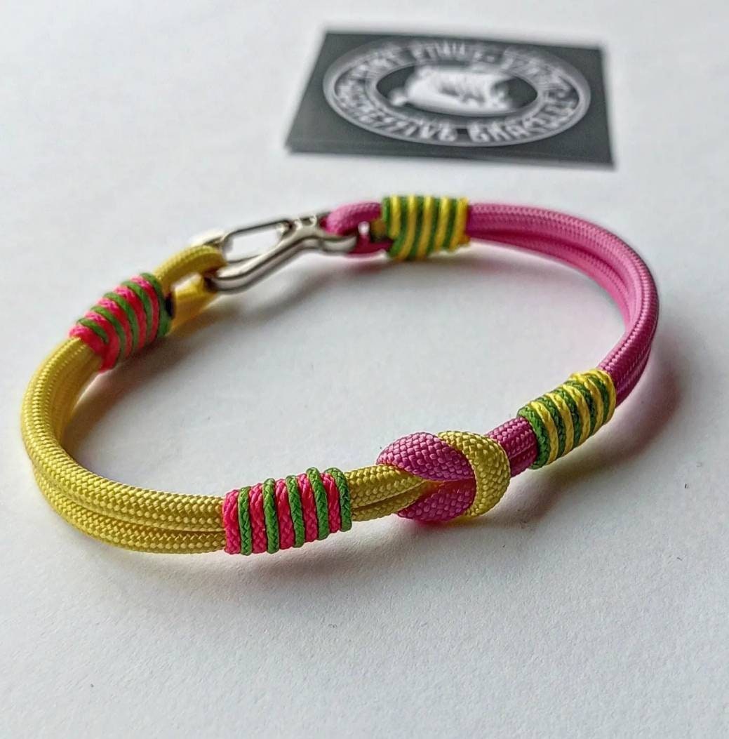 Pink and yellow thin Nordic paracord bangle with a carabiner. Made of parachute cord and celtic knots. Gift for women's.n's to