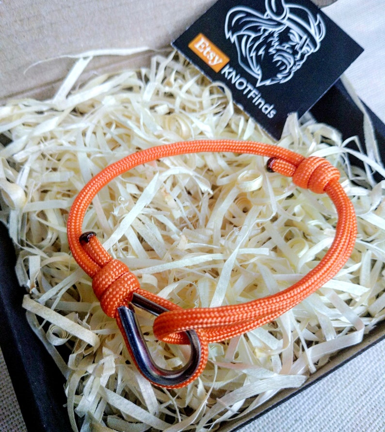 Orange thin bracelet made of paracord and Celtic knots. Stylish bracelet for men and women. A gift for a surfer, diver, skydiver.