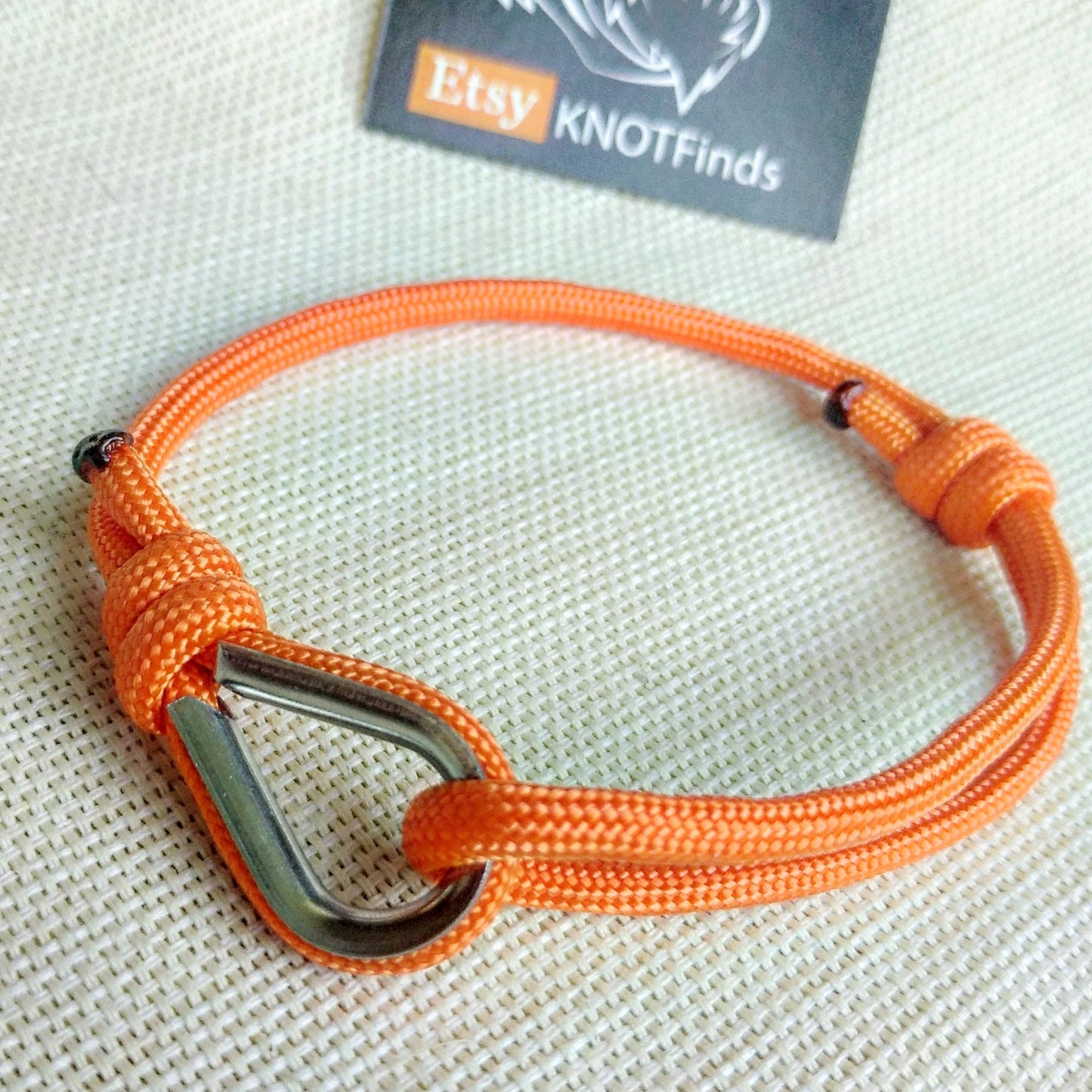 Orange thin bracelet made of paracord and Celtic knots. Stylish bracelet for men and women. A gift for a surfer, diver, skydiver.