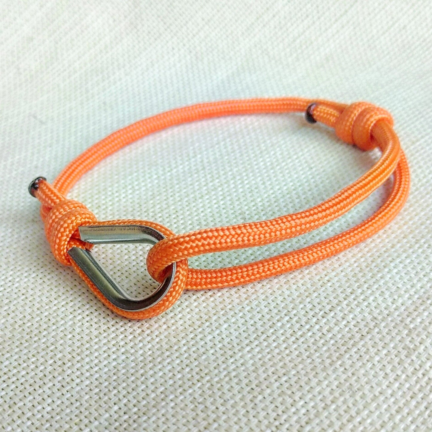 Orange thin bracelet made of paracord and Celtic knots. Stylish bracelet for men and women. A gift for a surfer, diver, skydiver.