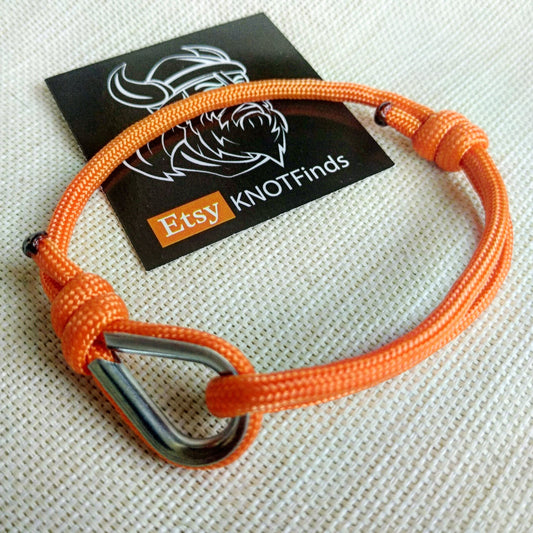 Orange thin bracelet made of paracord and Celtic knots. Stylish bracelet for men and women. A gift for a surfer, diver, skydiver.