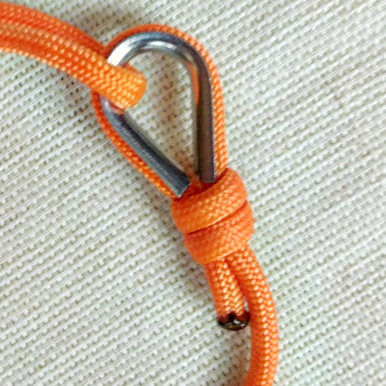 Orange thin bracelet made of paracord and Celtic knots. Stylish bracelet for men and women. A gift for a surfer, diver, skydiver.